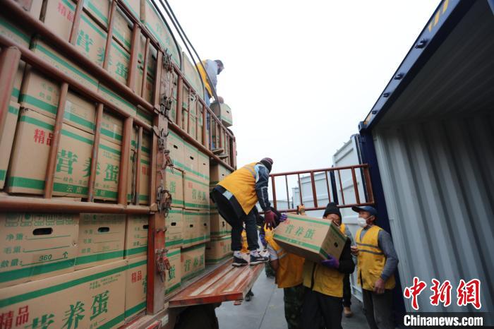 圖為鐵路裝卸作業(yè)人員正在將云南特色農(nóng)產(chǎn)品裝入集裝箱?！詈?攝