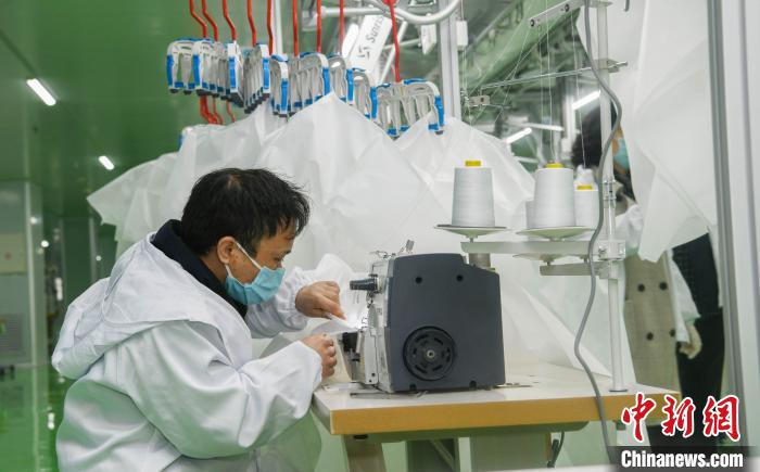 工人生產(chǎn)防護服，保障抗疫物資供應(yīng)。廣安市委宣傳部供圖