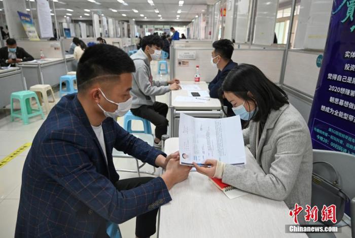 4月14日，招聘者在查看求職者簡歷。<a target='_blank'  data-cke-saved- >中新社</a>記者 王剛 攝