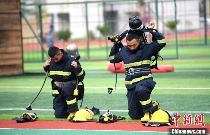 新消防員進(jìn)行穿戴空呼器展示?！⒅铱?攝