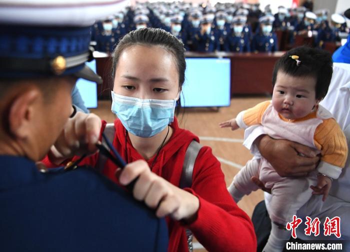 新消防員楊振的妻子彭莉與女兒現(xiàn)場見證丈夫加入“火焰藍(lán)”的神圣時刻。　劉忠俊 攝