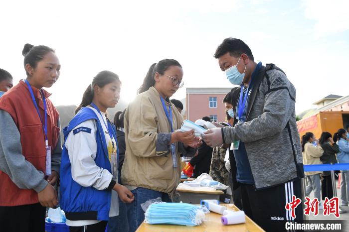 7月7日，考生在拉薩三高考點(diǎn)外領(lǐng)取口罩?！『闻罾?攝