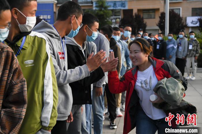 7月7日，拉薩三高考點(diǎn)外，領(lǐng)隊(duì)老師與考生擊掌鼓勁加油?！『闻罾?攝