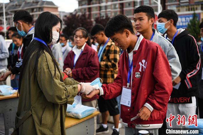 7月7日，考生在拉薩三高考點(diǎn)外測(cè)量體溫?！『闻罾?攝